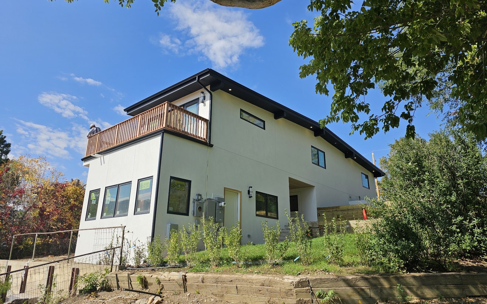 1450 High St after renovation — modern white stucco with stacked decks