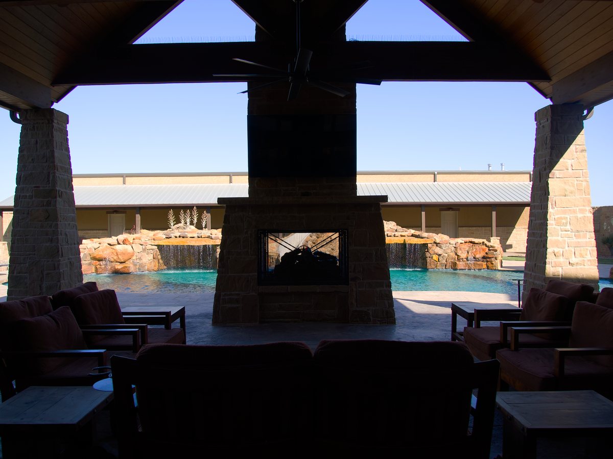 Covered outdoor living pavilion with masonry fireplace